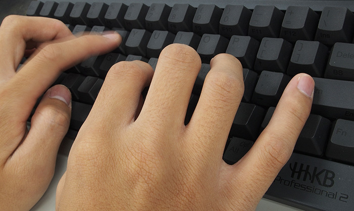 Fingers typing on keyboard.
