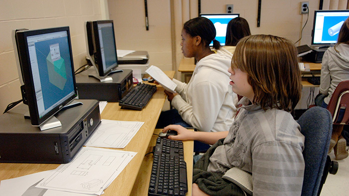 Children sitting in front of computers doing classwork.