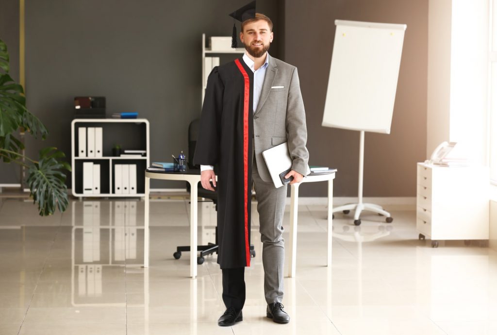 person in half a business suit and half a graduation gown